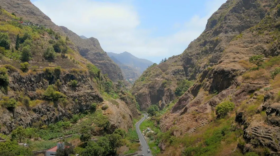 Winding road cuts through a dramatic mountain valley