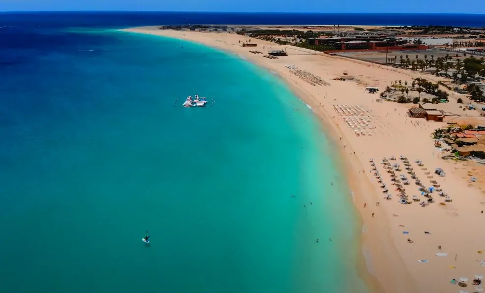 Pristine turquoise water laps a pristine white-sand beach