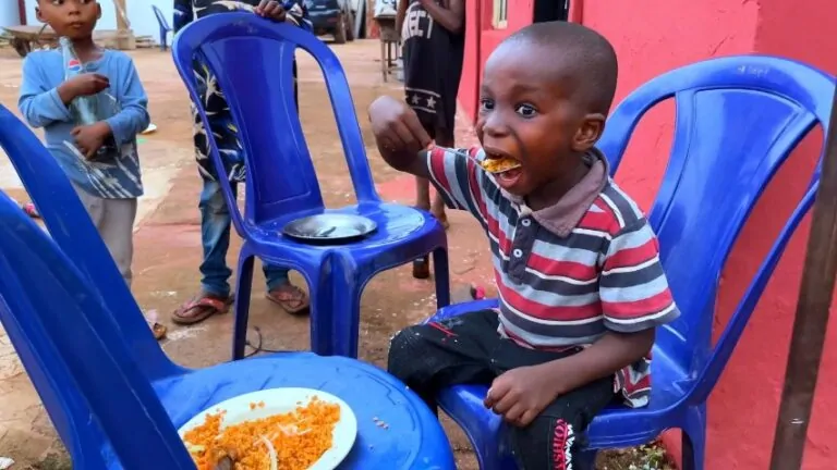 A young boy savors a meal, his face alight with joy
