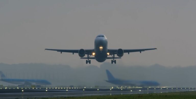 A commercial airliner ascends gracefully, lights illuminating its path