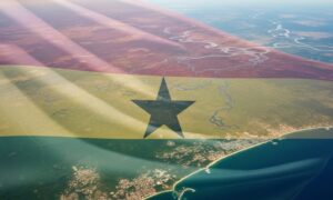 Waving flag of Ghana displayed over a scenic landscape and sea in a 3D illustration