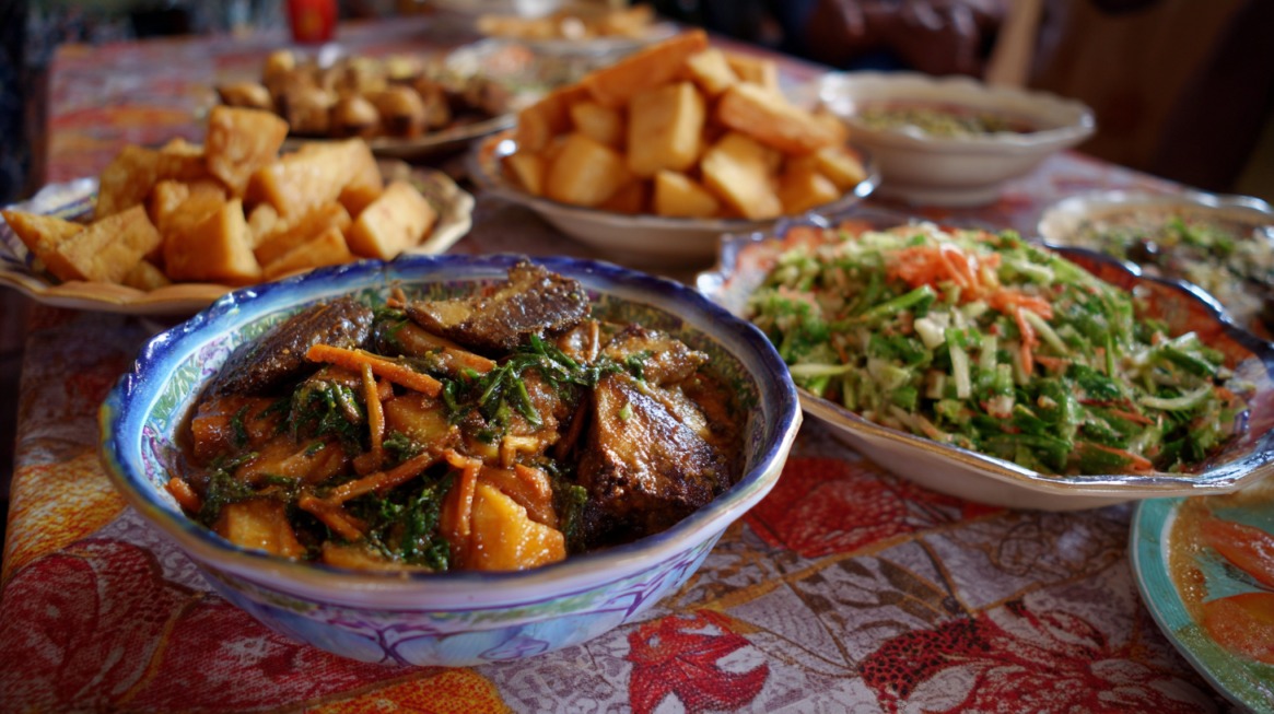 A colorful spread of Ivorian cuisine with fried plantains, vegetables, and stews on a patterned tablecloth