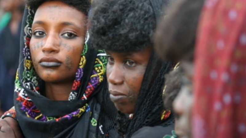 Fulani women wearing traditional embroidered clothing and facial tattoos that represent beauty and cultural pride