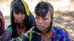 Fulani people in traditional attire with braided hairstyles and facial tattoos