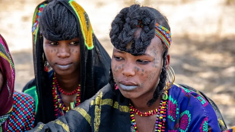 Fulani people in traditional attire with braided hairstyles and facial tattoos