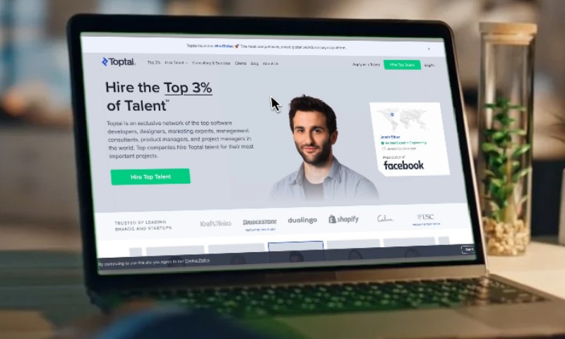 Laptop screen displaying Toptal's website with a focus on hiring top talent