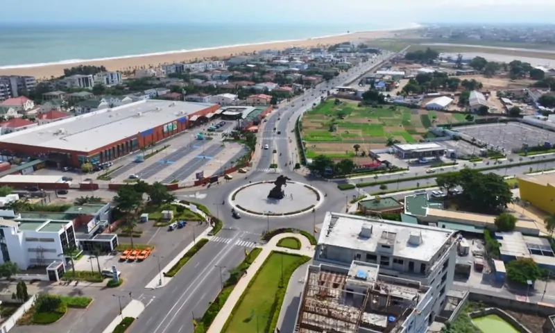 Aerial view of a coastal cityscape featuring a prominent roundabout