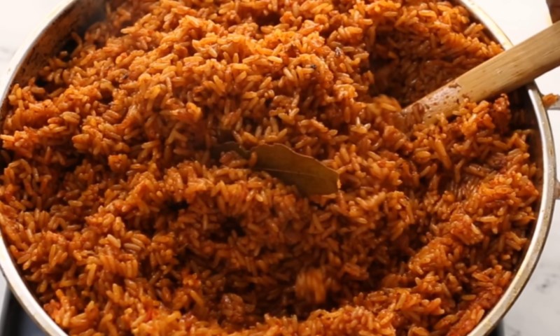 A pot filled with fluffy, vibrant orange jollof rice