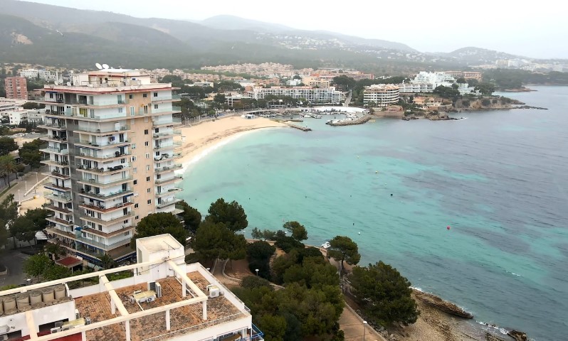 Aerial view of a coastal town with turquoise waters and sandy beaches